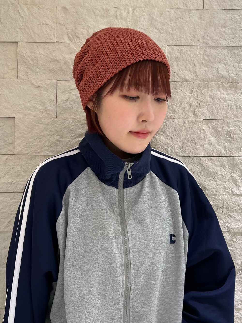 ブラック系のスニーカー、レッド系のニットキャップ/ビーニーを着用したレディースの春コーディネートの3枚目の写真