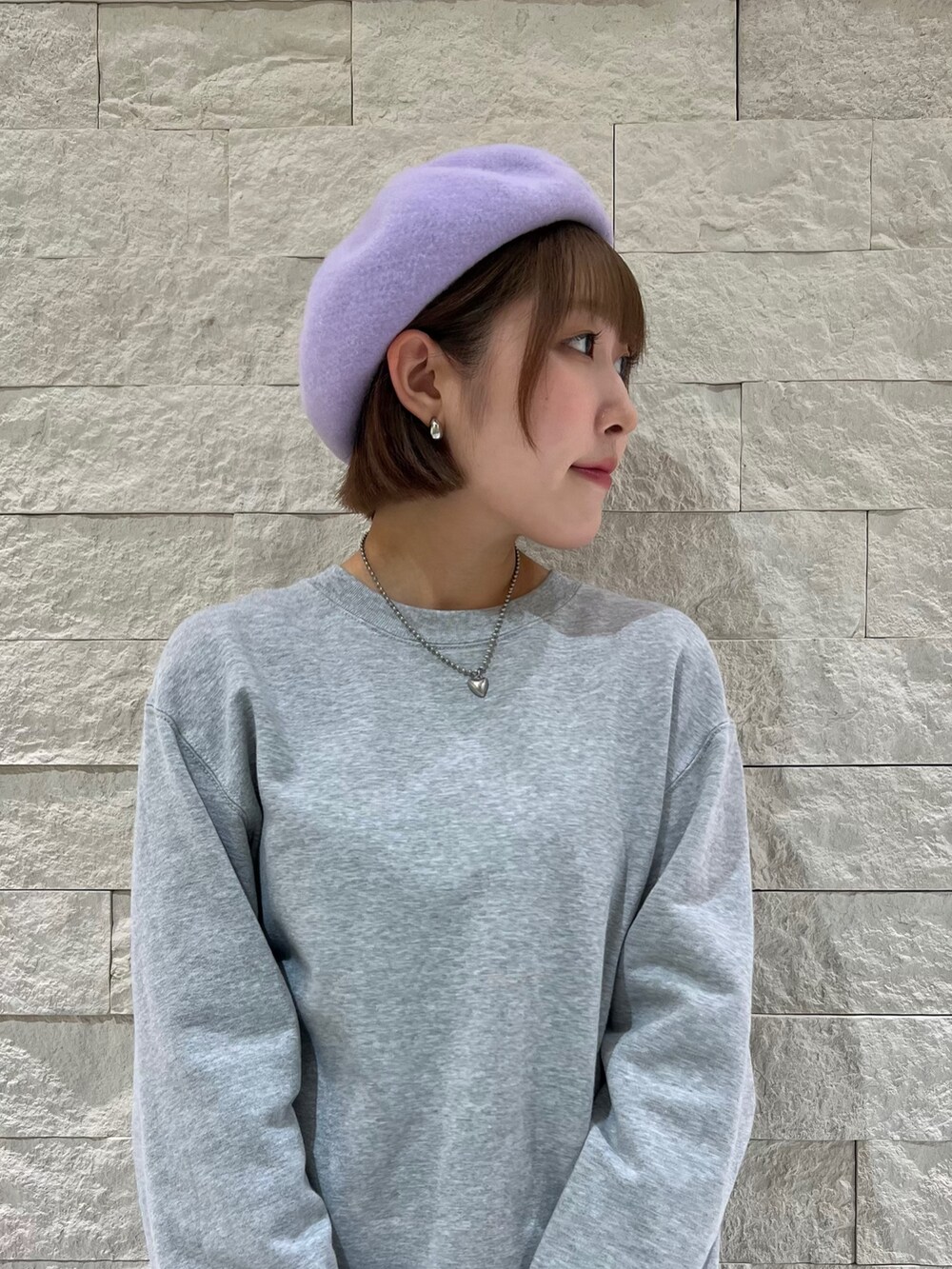 グレー系のスウェット、ブラック系のローファー、パープル系のハンチング/ベレー帽を着用したレディースの秋コーディネートの2枚目の写真