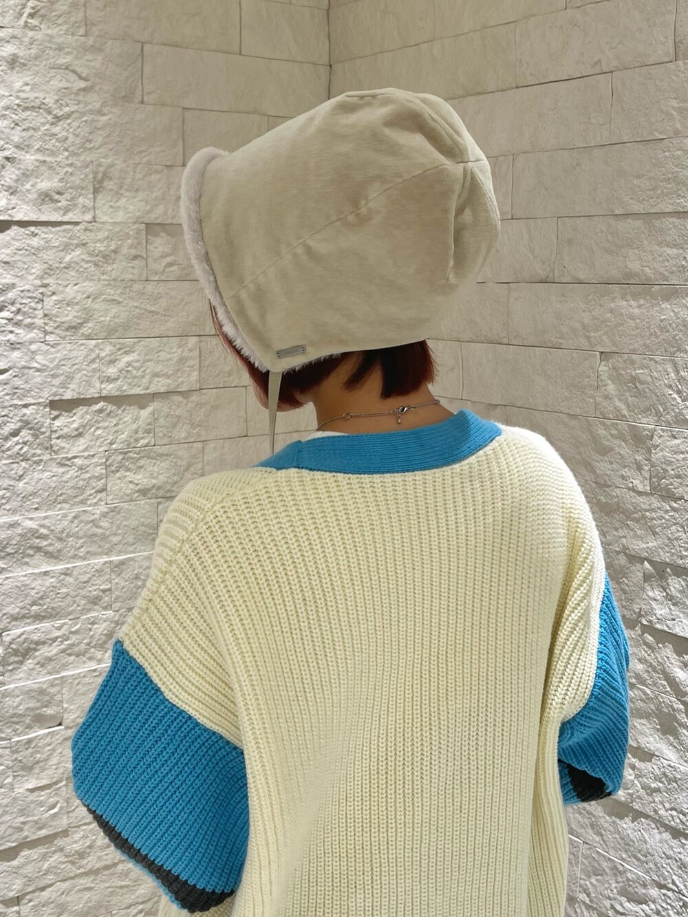 ホワイト系のカーディガン/ボレロ、ブルー系のスニーカー、ホワイト系のハットを着用したレディースの冬コーディネートの3枚目の写真