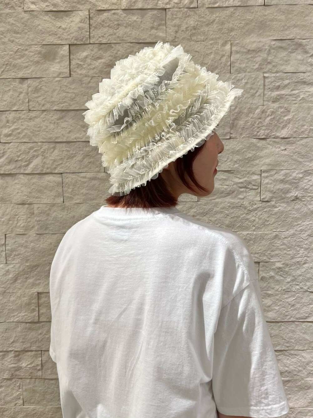 ピンク系のハットを着用したレディースの夏コーディネートの6枚目の写真