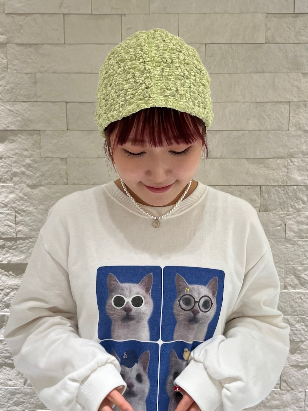 ホワイト系のスウェット、グレー系のスカート、グリーン系のニットキャップ/ビーニーを着用したレディースの冬コーディネートの4枚目の写真