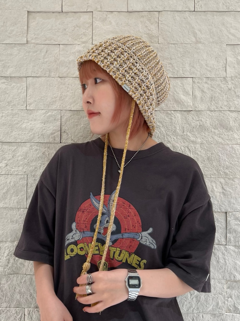 グレー系のスニーカー、イエロー系のハットを着用したレディースの秋コーディネートの3枚目の写真