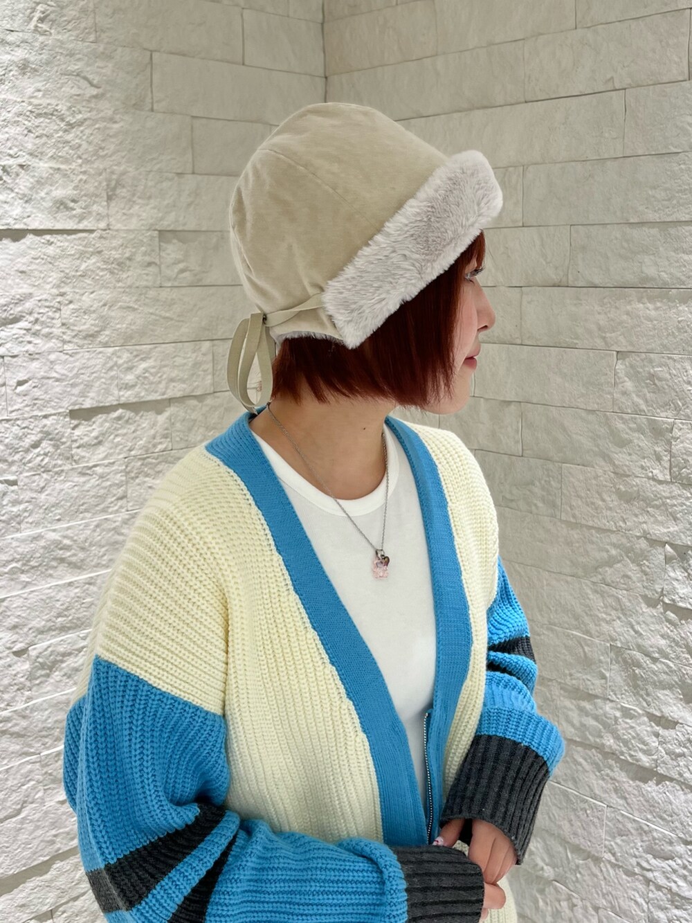 ホワイト系のカーディガン/ボレロ、ブルー系のスニーカー、ホワイト系のハットを着用したレディースの冬コーディネートの4枚目の写真