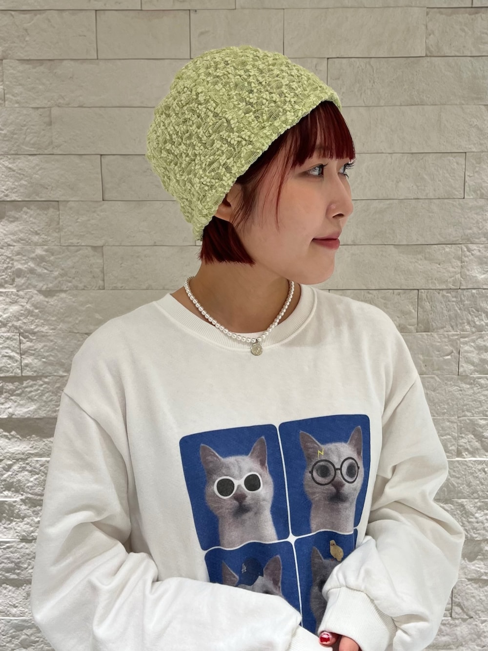 ホワイト系のスウェット、グレー系のスカート、グリーン系のニットキャップ/ビーニーを着用したレディースの冬コーディネートの2枚目の写真