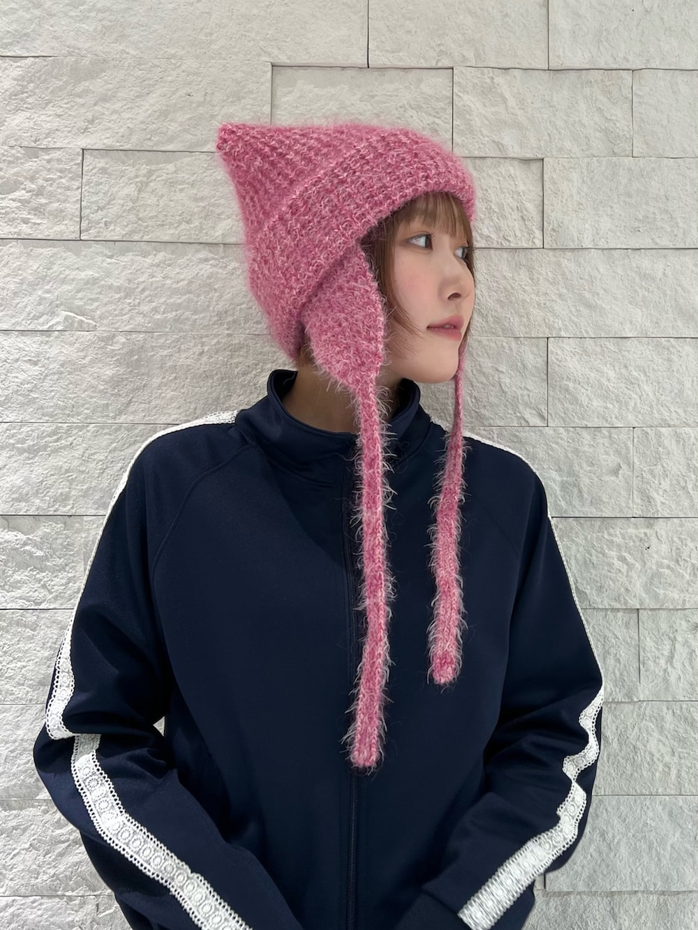 グレー系のスカート、グレー系のスニーカー、ピンク系のニットキャップ/ビーニーを着用したレディースの秋コーディネートの2枚目の写真