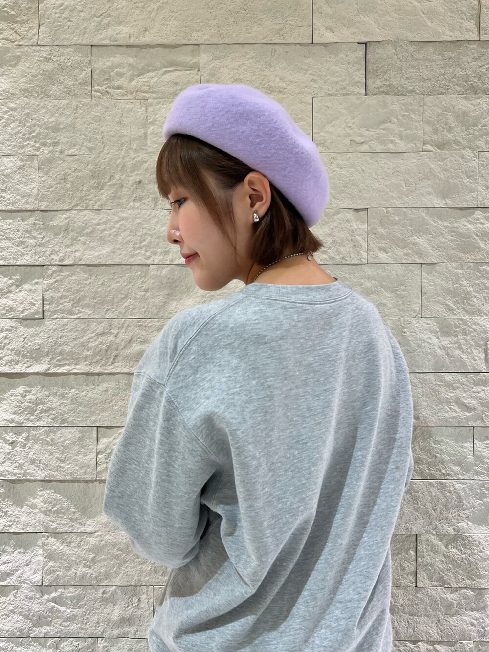 グレー系のスウェット、ブラック系のローファー、パープル系のハンチング/ベレー帽を着用したレディースの秋コーディネートの3枚目の写真