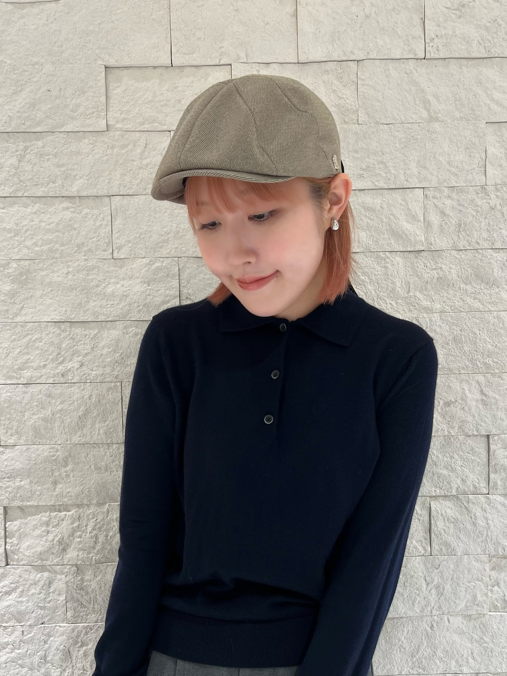 ブルー系のニット/セーター、グレー系のスラックス、ベージュ系のハンドバッグを着用したレディースの秋コーディネートの2枚目の写真