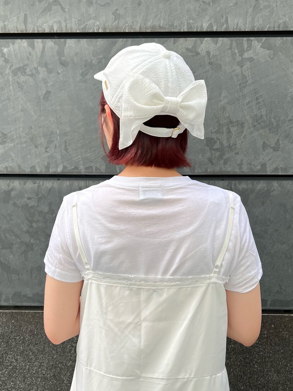 ホワイト系のキャップを着用したレディースの夏コーディネートの4枚目の写真