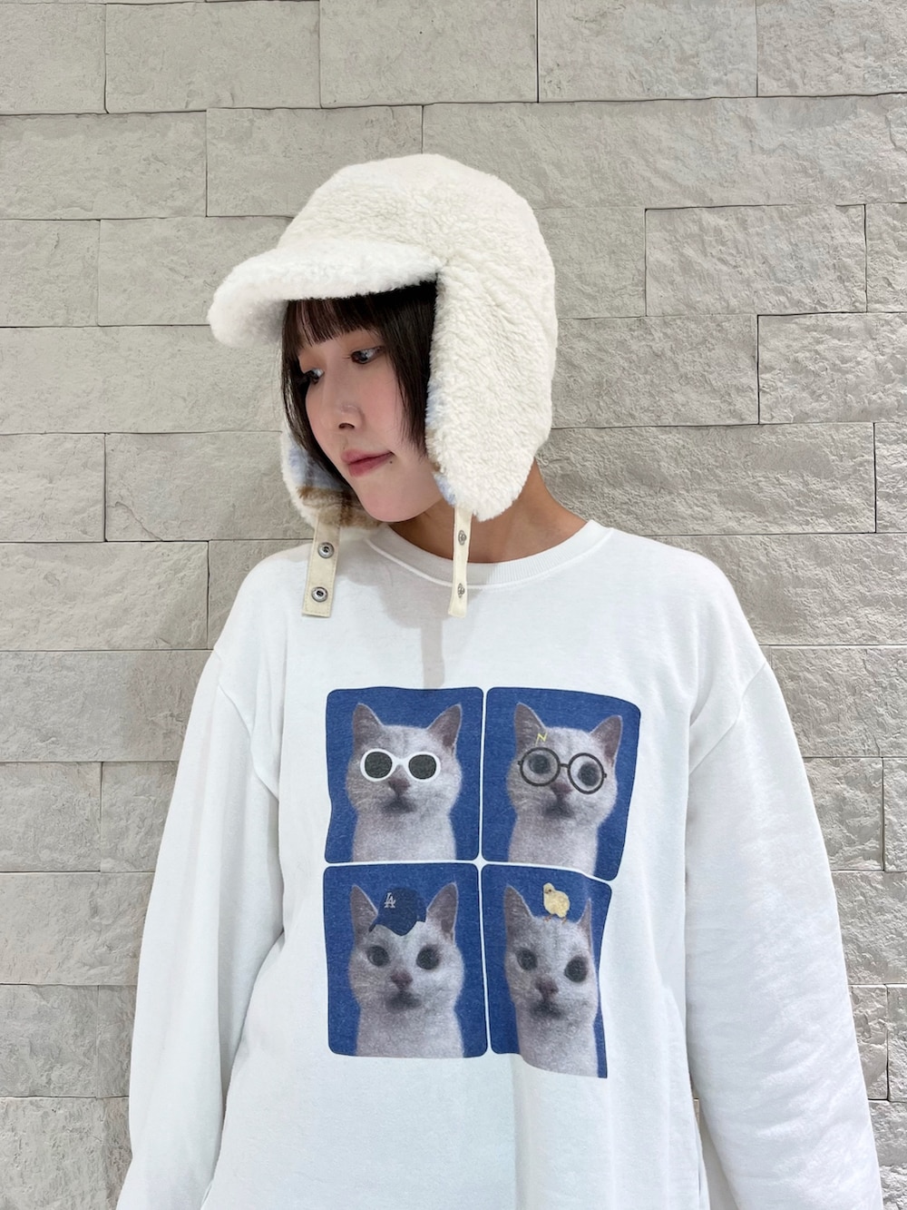 ホワイト系のスウェット、ブラウン系のパンツ、ブルー系のスニーカーを着用したレディースの秋コーディネートの4枚目の写真