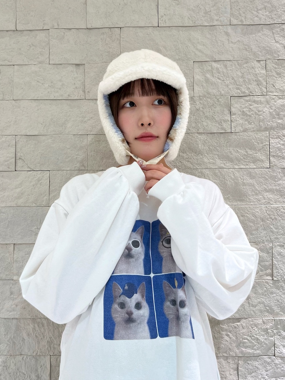 ホワイト系のスウェット、ブラウン系のパンツ、ブルー系のスニーカーを着用したレディースの秋コーディネートの3枚目の写真