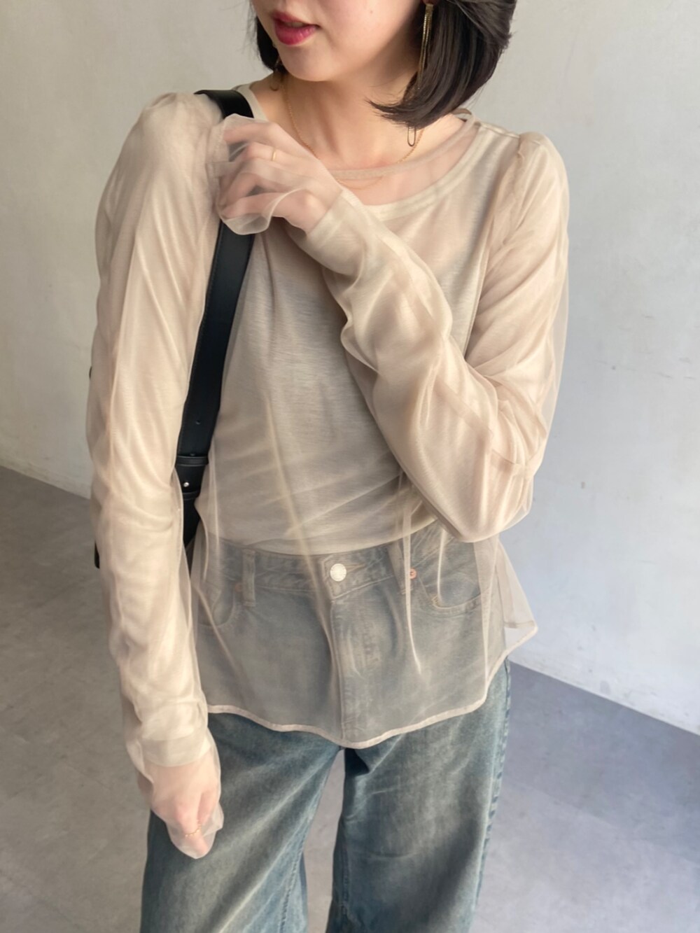 ブラック系のショルダーバッグ、ベージュ系のTシャツ/カットソーを着用したレディースの春コーディネートの4枚目の写真