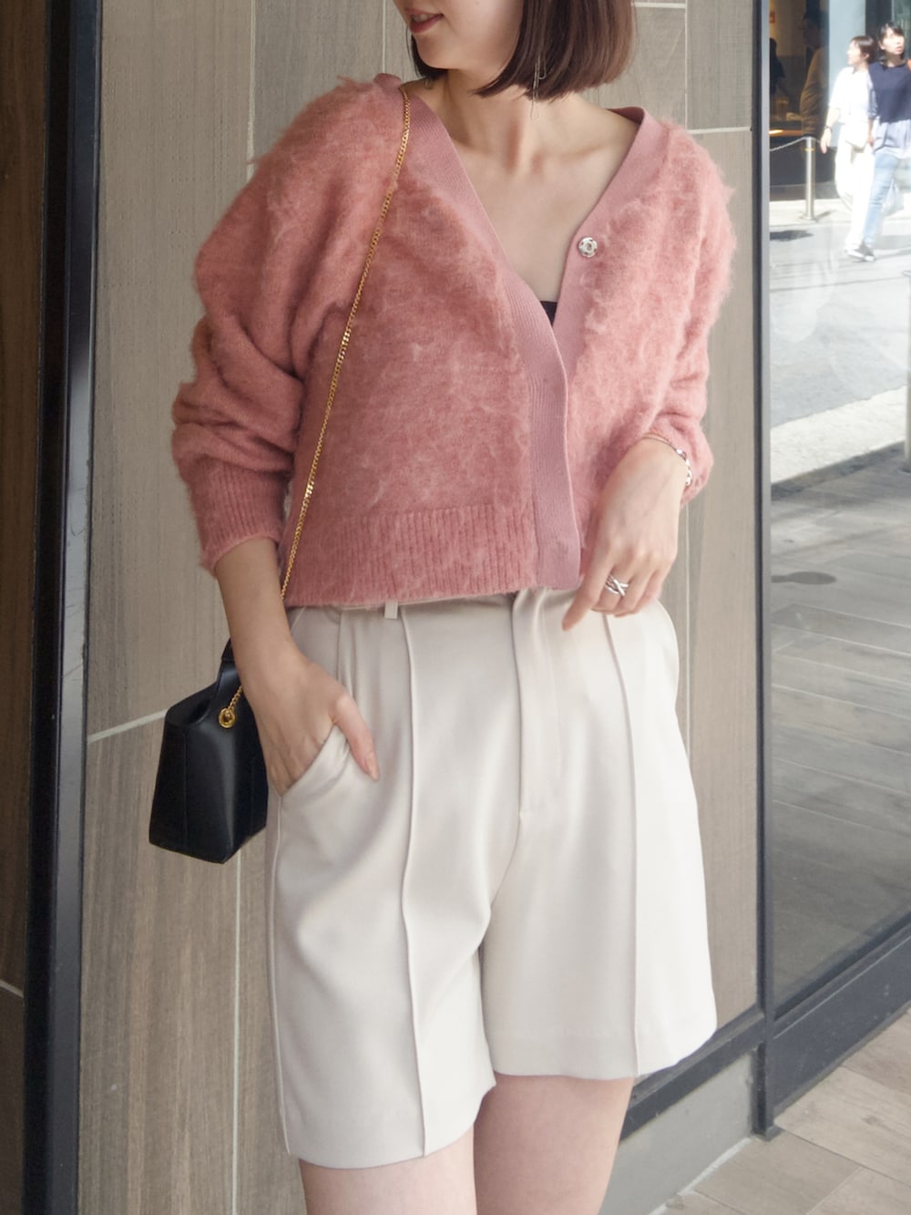 ピンク系のカーディガン/ボレロ、ホワイト系のその他パンツ、ブラック系のブーツを着用したレディースの秋コーディネートの3枚目の写真