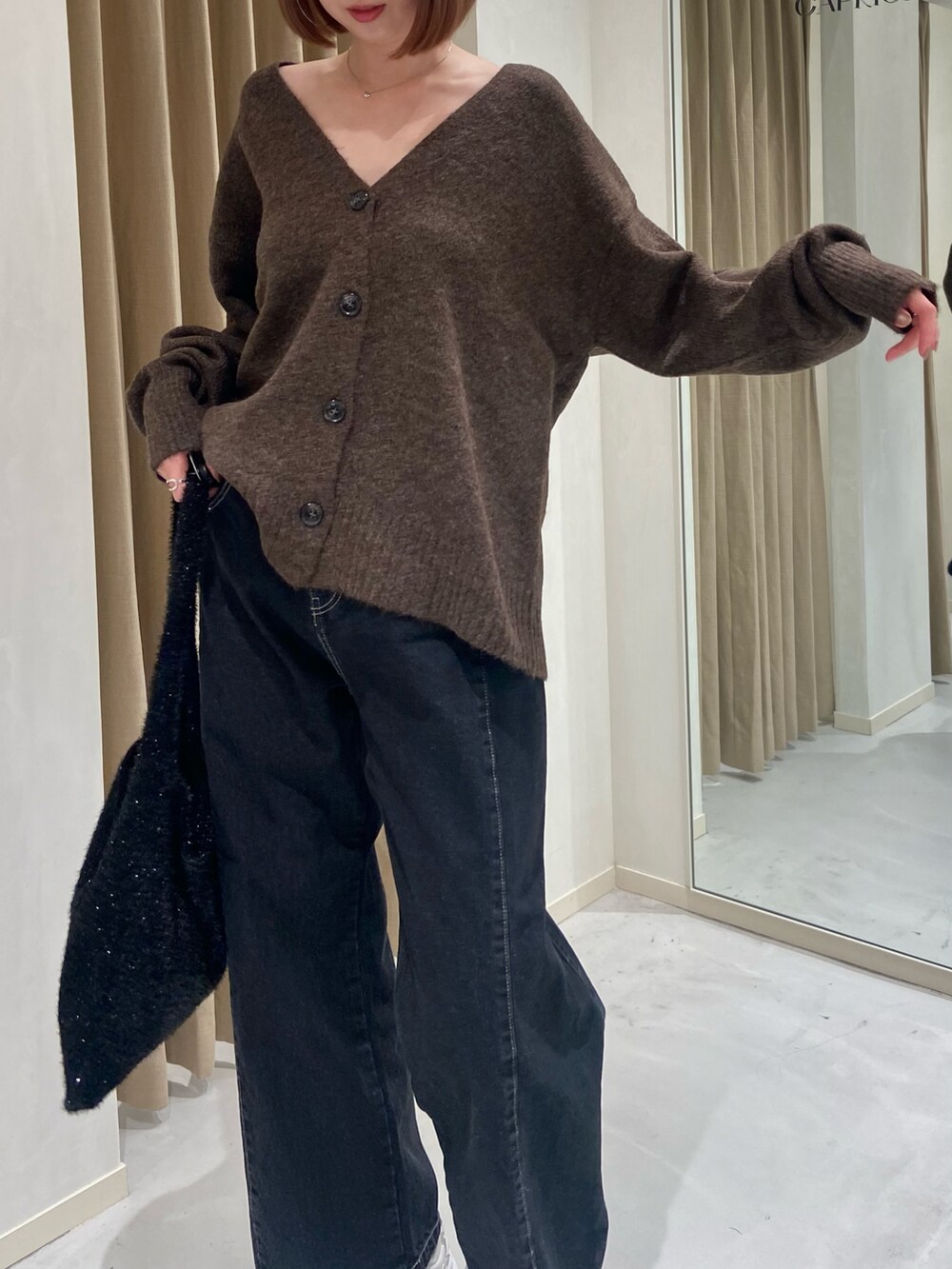 ブラウン系のカーディガン/ボレロ、ブラック系のデニムパンツ、ブラック系のショルダーバッグを着用したレディースの冬コーディネートの3枚目の写真