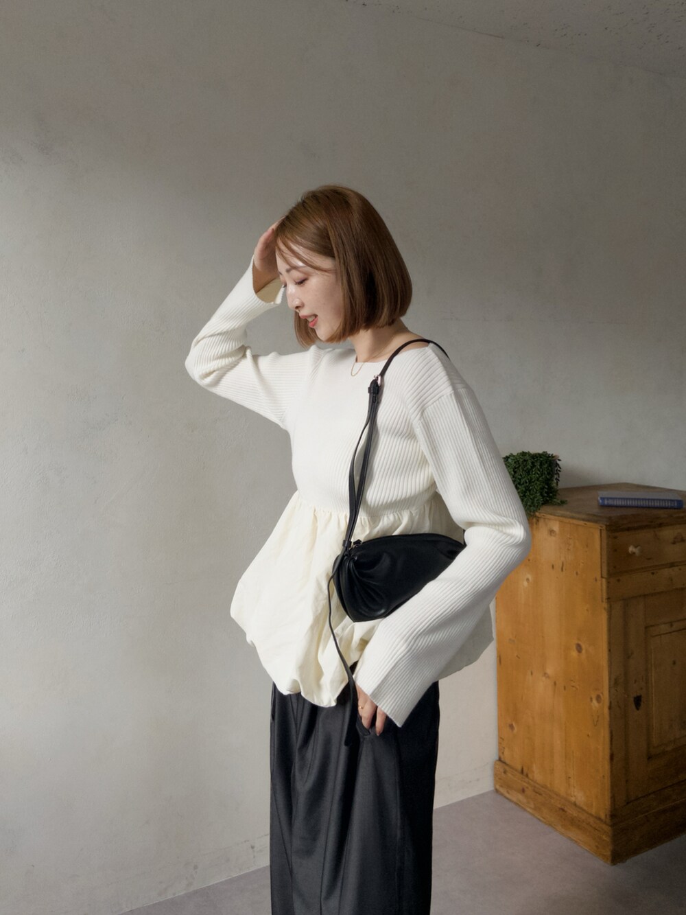 ホワイト系のニット/セーター、グレー系のパンツを着用したレディースの冬コーディネートの3枚目の写真