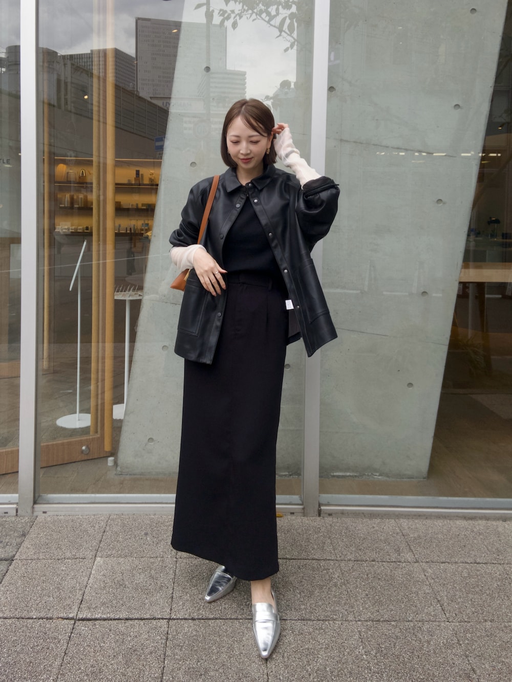 ブラック系のニット/セーター、ブラック系のブルゾン、ブラック系のスカートを着用したレディースの秋コーディネートの2枚目の写真