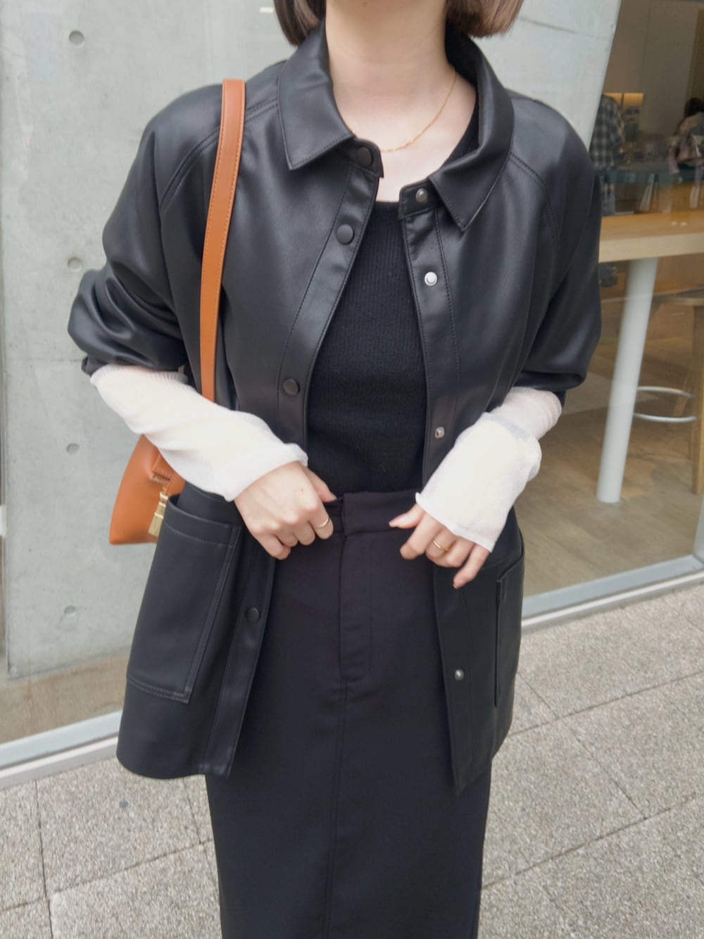 ブラック系のニット/セーター、ブラック系のブルゾン、ブラック系のスカートを着用したレディースの秋コーディネートの3枚目の写真