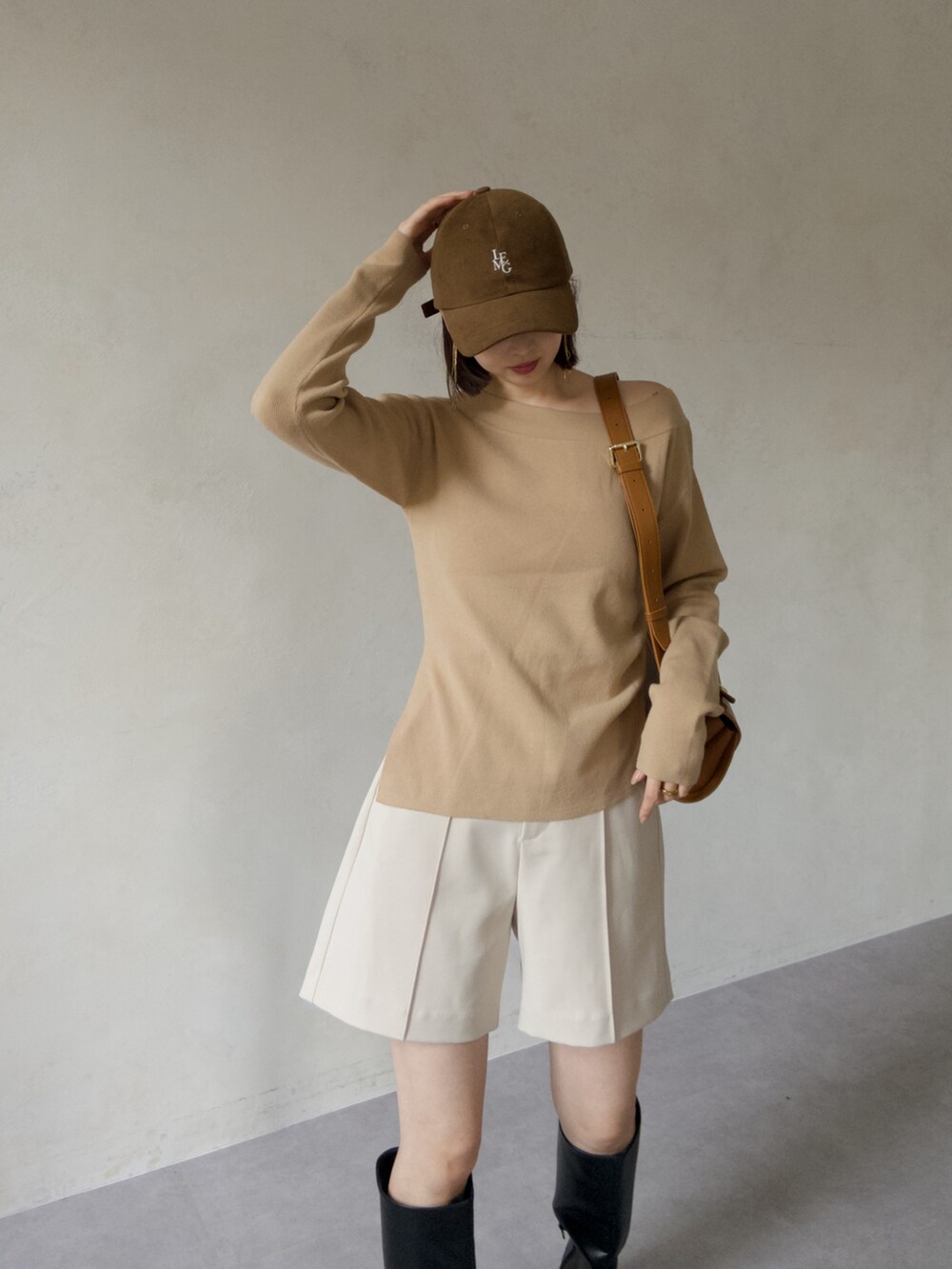 ベージュ系のニット/セーター、ホワイト系のその他パンツ、ブラック系のブーツを着用したレディースの秋コーディネートの3枚目の写真