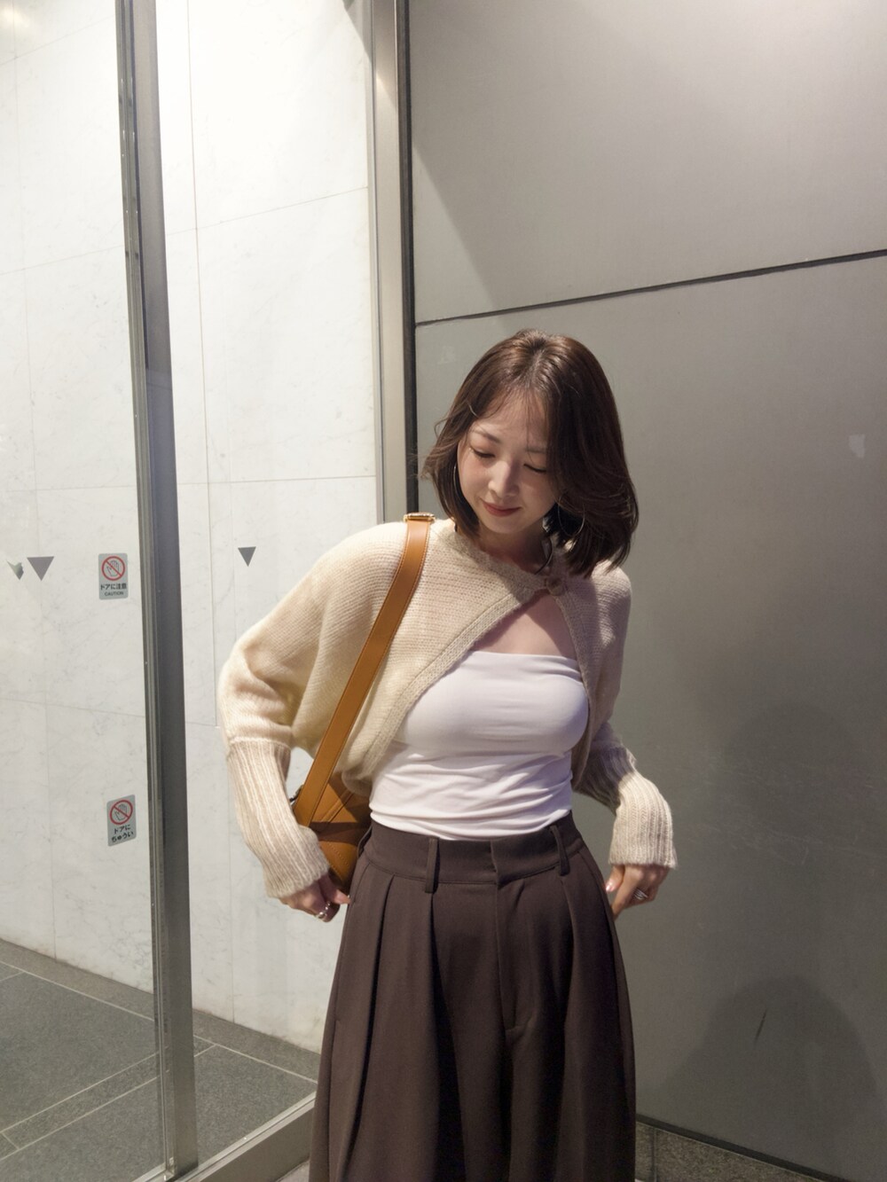 ベージュ系のカーディガン/ボレロ、ブラウン系のその他パンツ、ベージュ系のショルダーバッグを着用したレディースの秋コーディネートの3枚目の写真