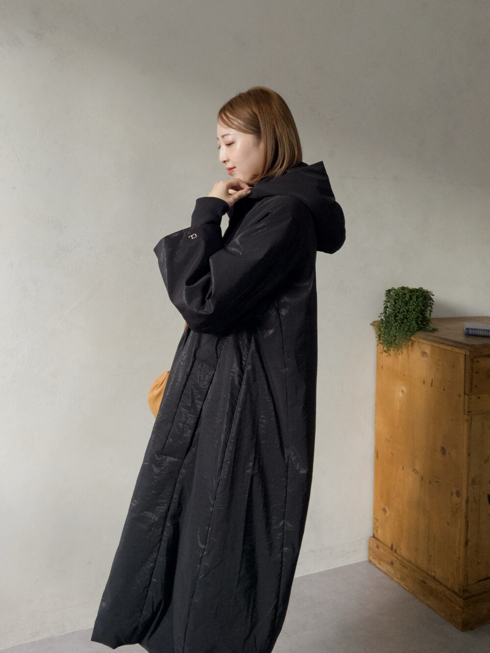 ブラック系のその他アウター、ブラック系のパンプス、イエロー系のショルダーバッグを着用したレディースの冬コーディネートの4枚目の写真