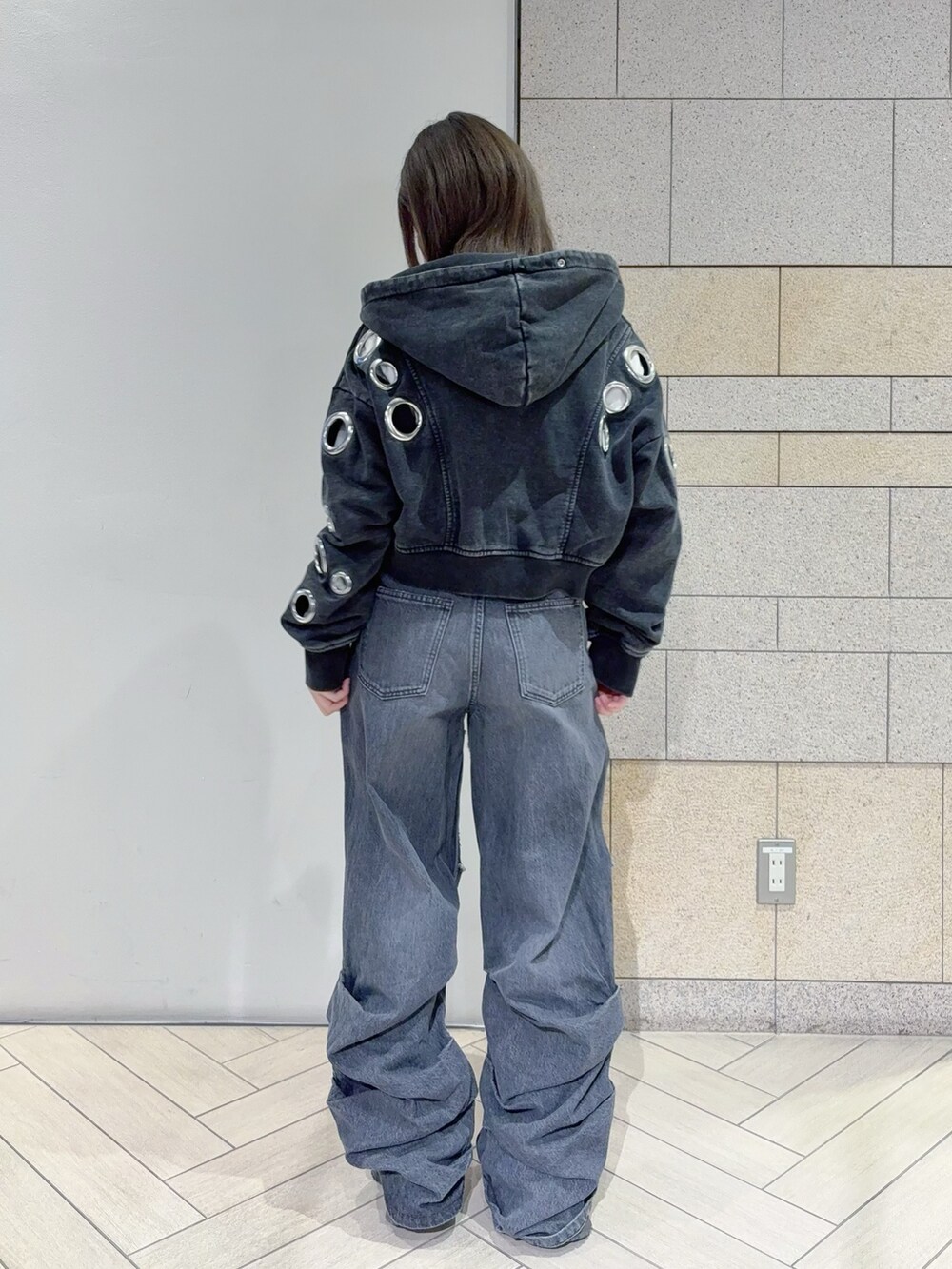 ブラック系のパーカー、ブラック系のデニムパンツを着用したレディースの秋コーディネートの3枚目の写真