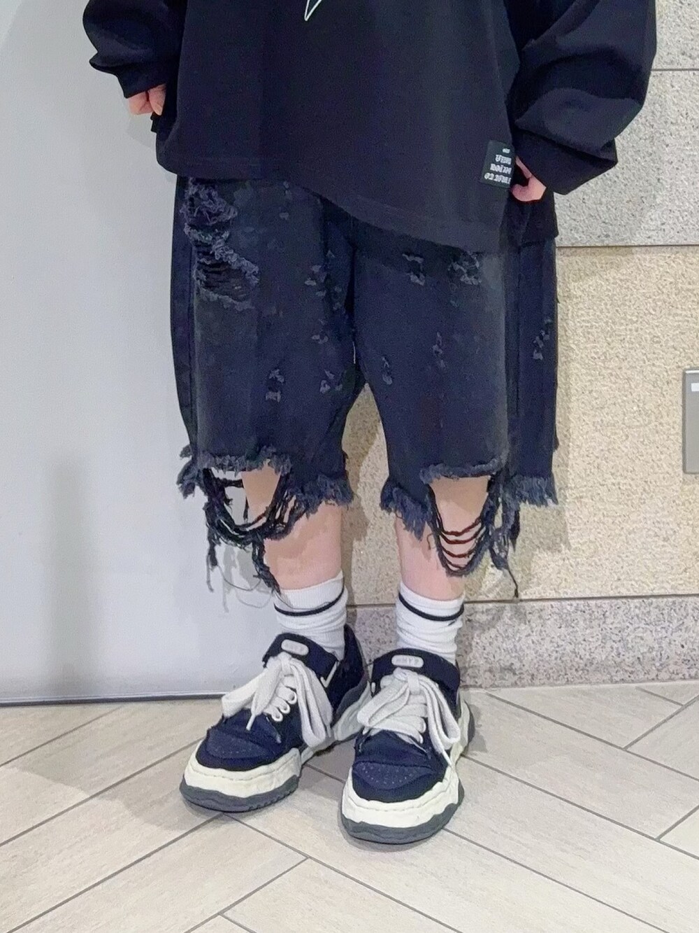 ブラック系のTシャツ/カットソー、ブラック系のデニムパンツを着用したレディースの秋コーディネートの5枚目の写真