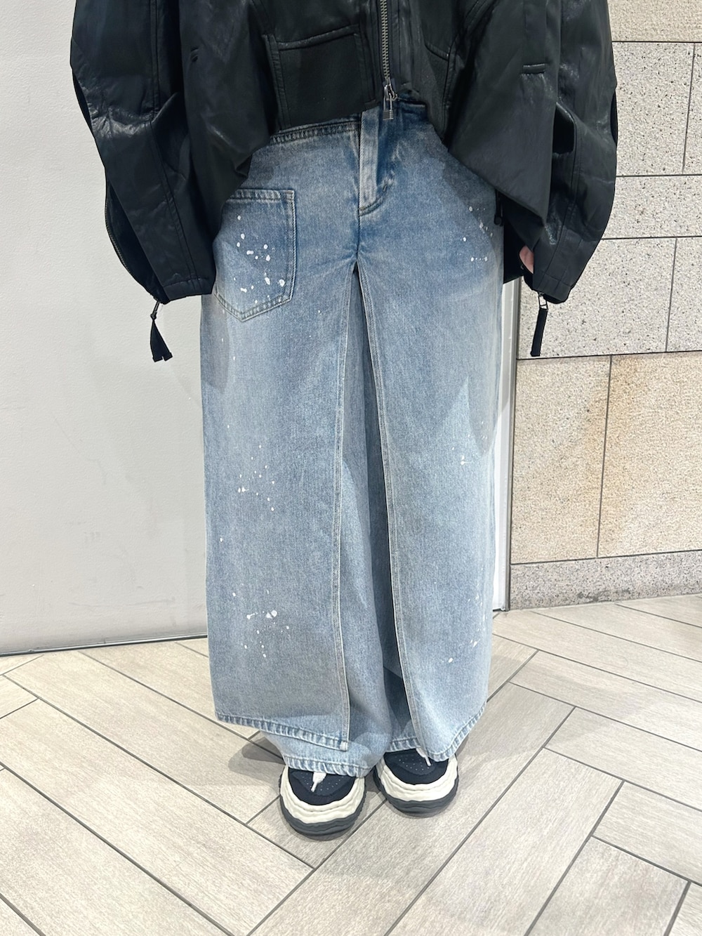 ブラック系のブルゾン、ブラック系のニット/セーター、ブルー系のデニムパンツを着用したレディースの夏コーディネートの5枚目の写真