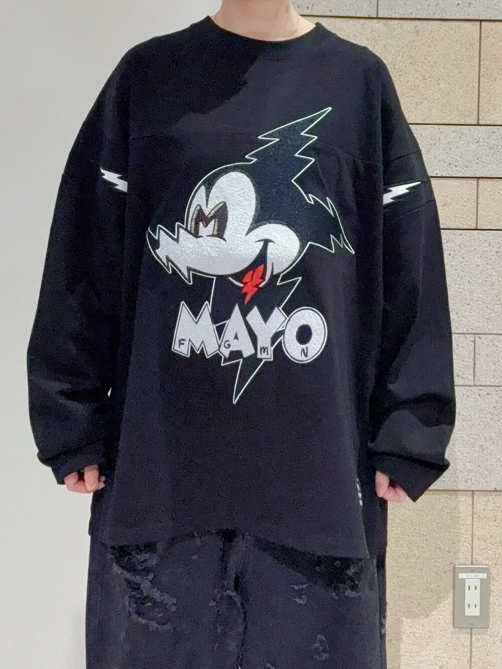 ブラック系のTシャツ/カットソー、ブラック系のデニムパンツを着用したレディースの秋コーディネートの4枚目の写真