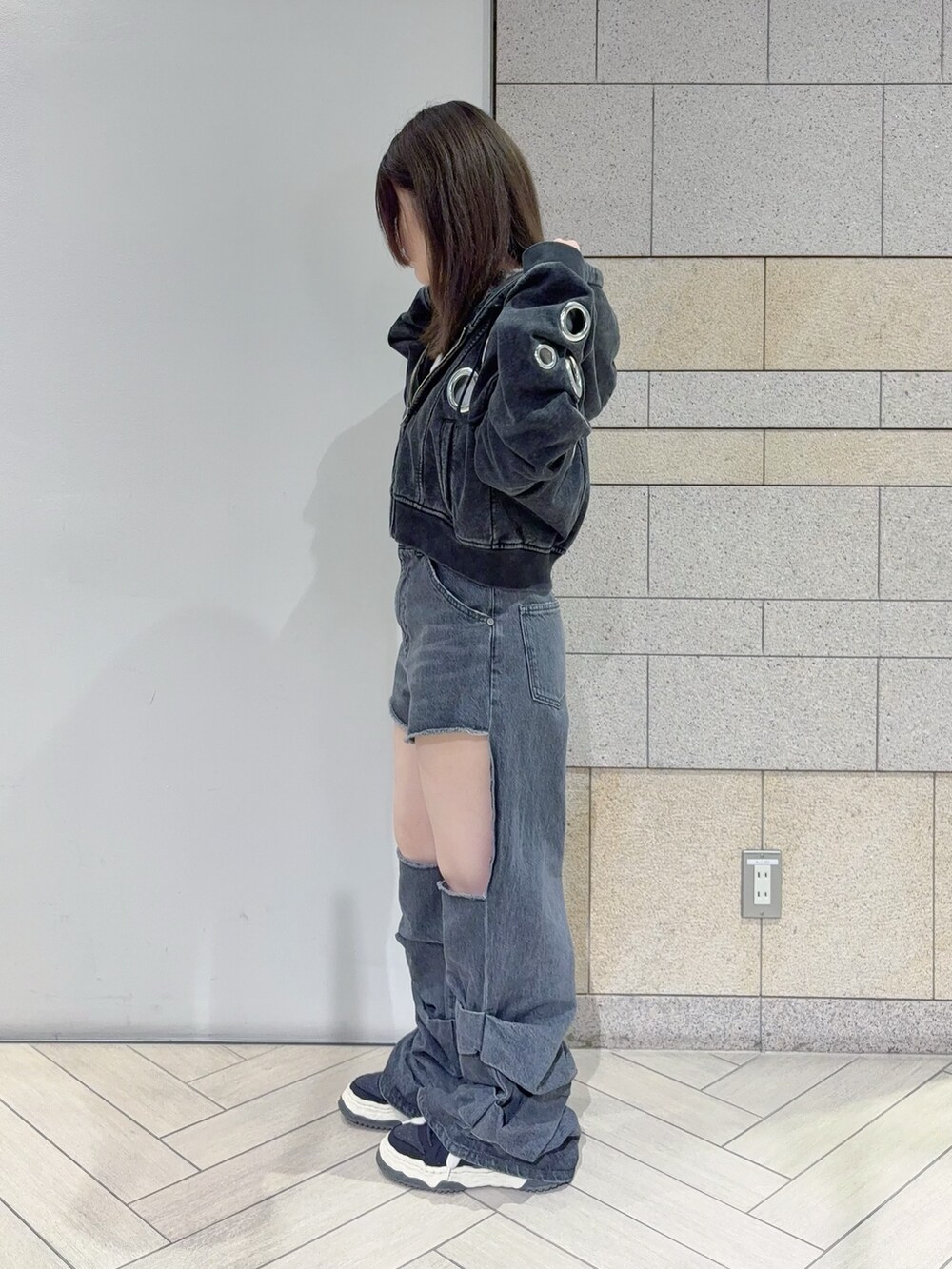 ブラック系のパーカー、ブラック系のデニムパンツを着用したレディースの秋コーディネートの2枚目の写真