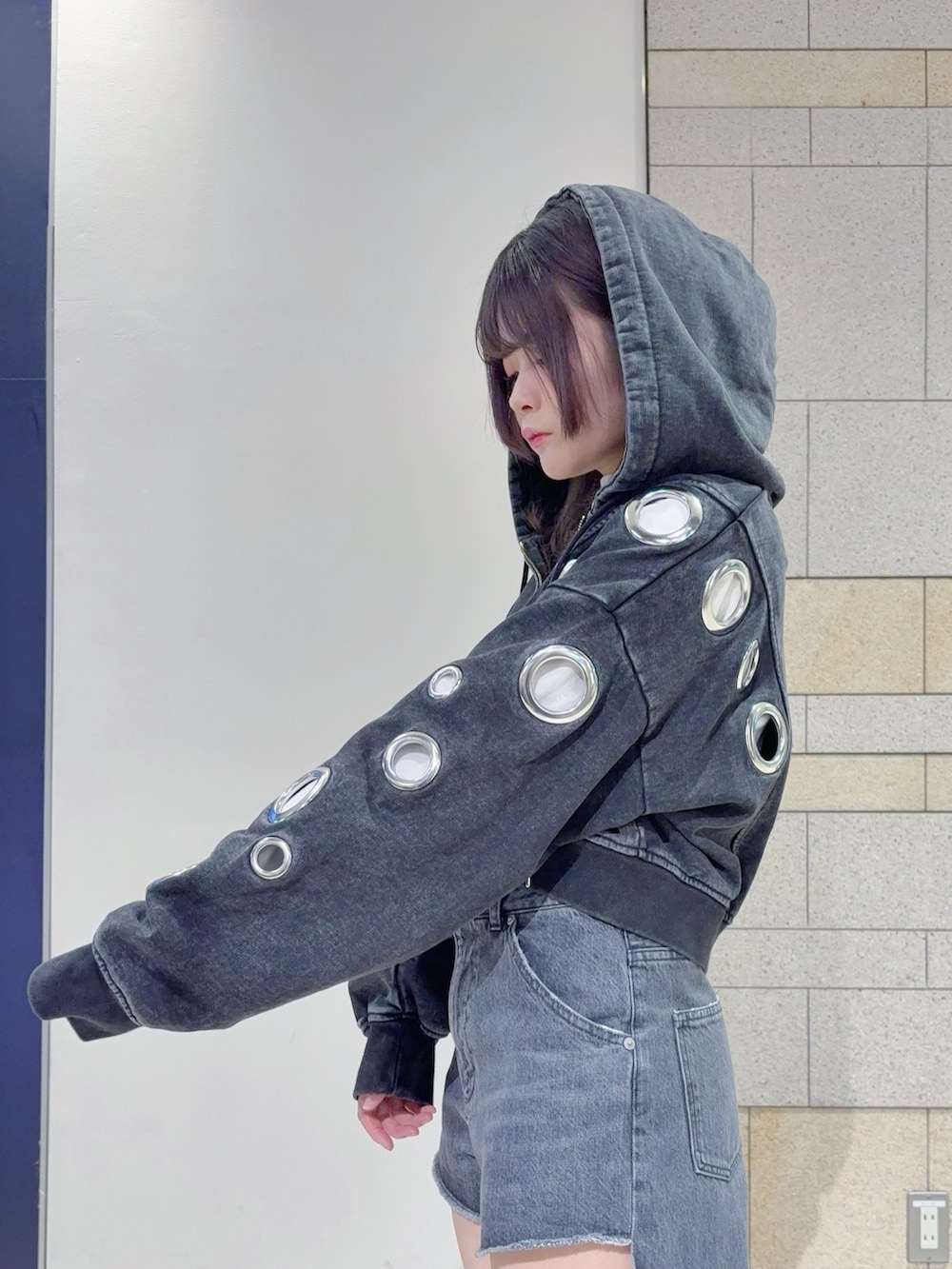 ブラック系のパーカー、ブラック系のデニムパンツを着用したレディースの秋コーディネートの5枚目の写真