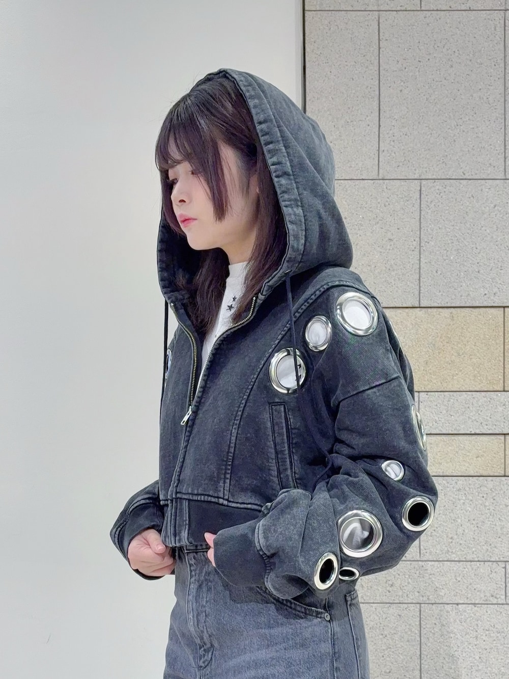 ブラック系のパーカー、ブラック系のデニムパンツを着用したレディースの秋コーディネートの4枚目の写真