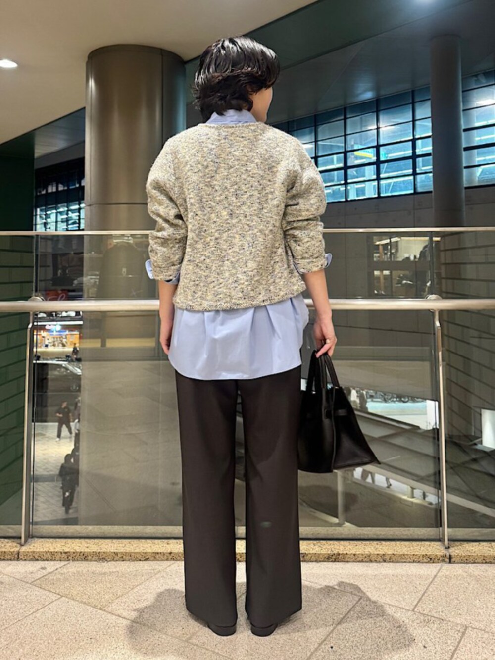 ブルー系のシャツ/ブラウス、ブラック系のトートバッグ、ベージュ系のカーディガン/ボレロを着用したレディースの秋コーディネートの4枚目の写真