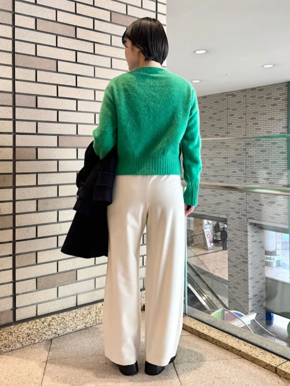 ブラック系のブーツ、ブラック系のショルダーバッグ、ブルー系のステンカラーコートを着用したレディースの冬コーディネートの4枚目の写真