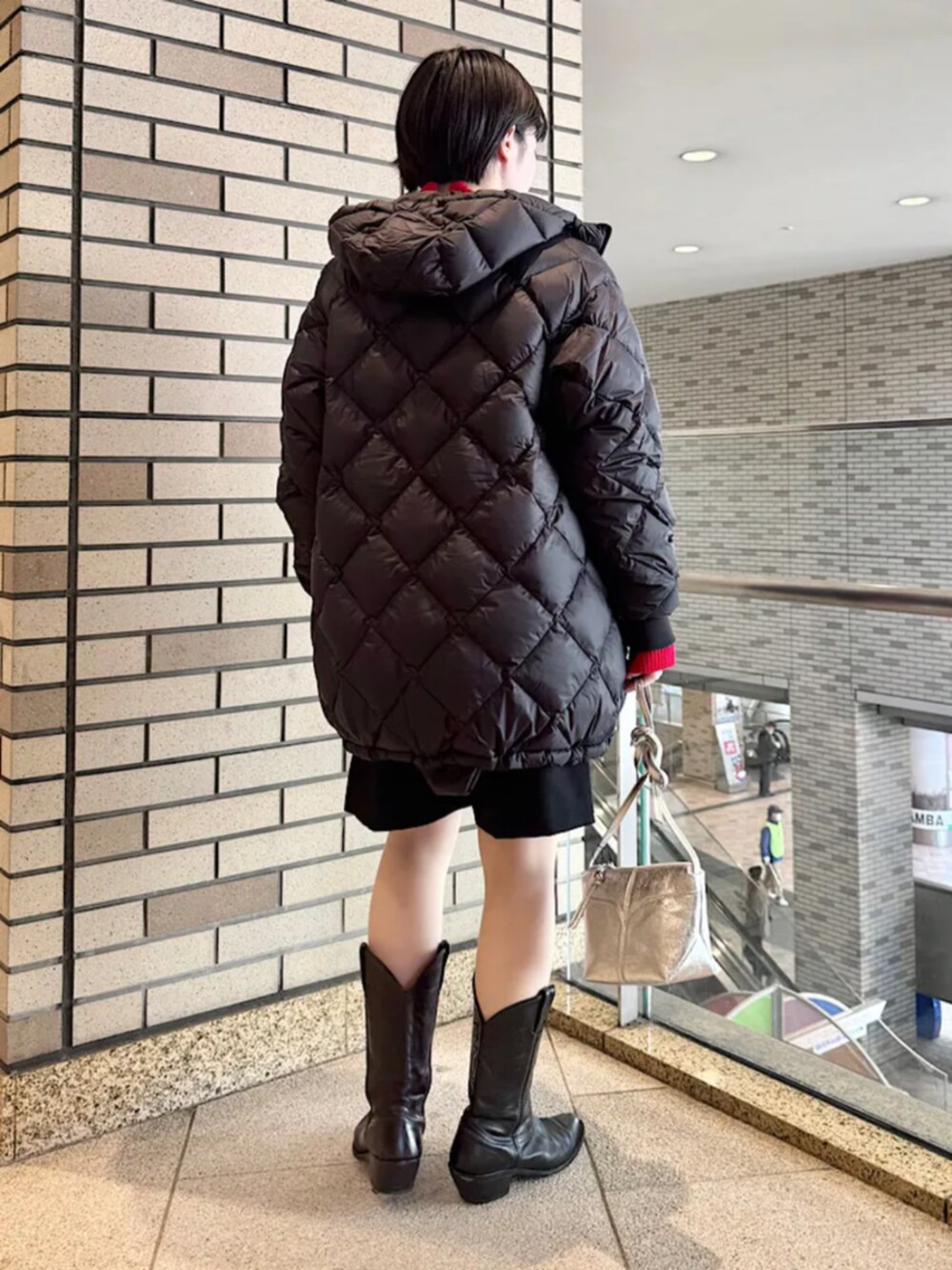 ブラック系のその他パンツ、ブラック系のダウンジャケット/コート、レッド系のニット/セーターを着用したレディースの冬コーディネートの3枚目の写真