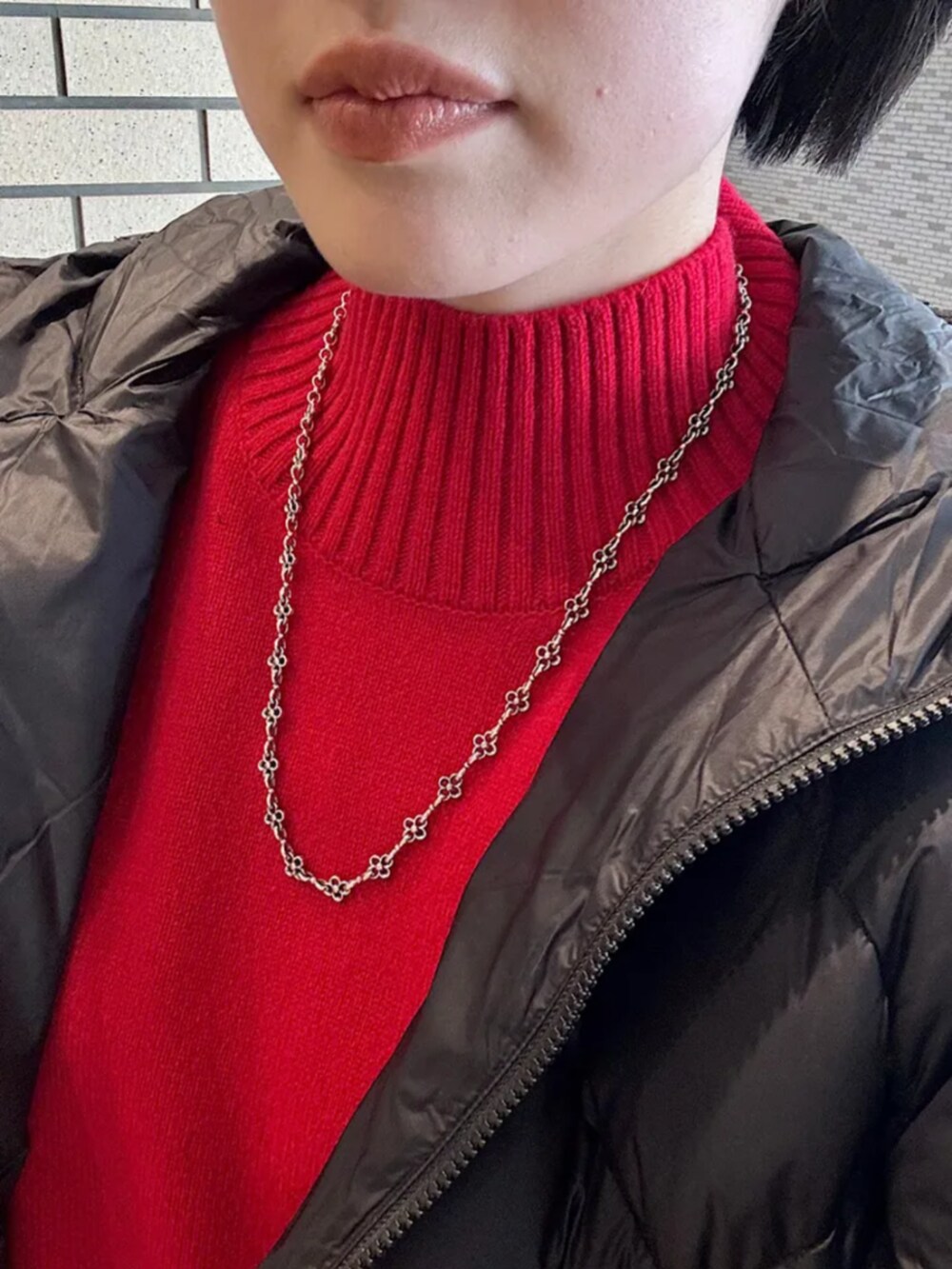 ブラック系のその他パンツ、ブラック系のダウンジャケット/コート、レッド系のニット/セーターを着用したレディースの冬コーディネートの4枚目の写真