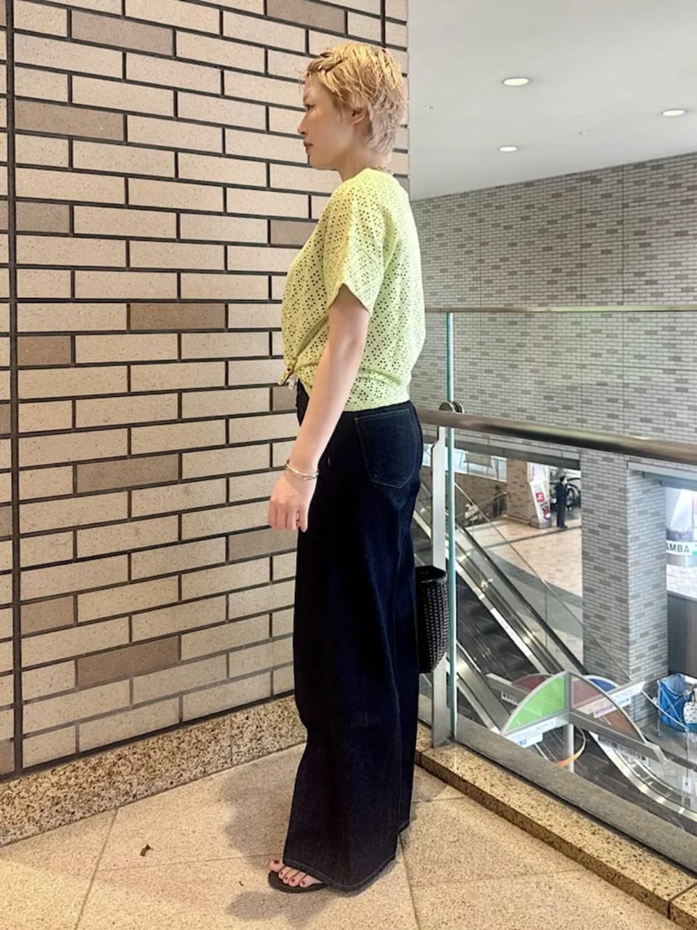 ブラウン系のサンダル、グリーン系のTシャツ/カットソー、ブルー系のデニムパンツを着用したレディースの春コーディネートの2枚目の写真