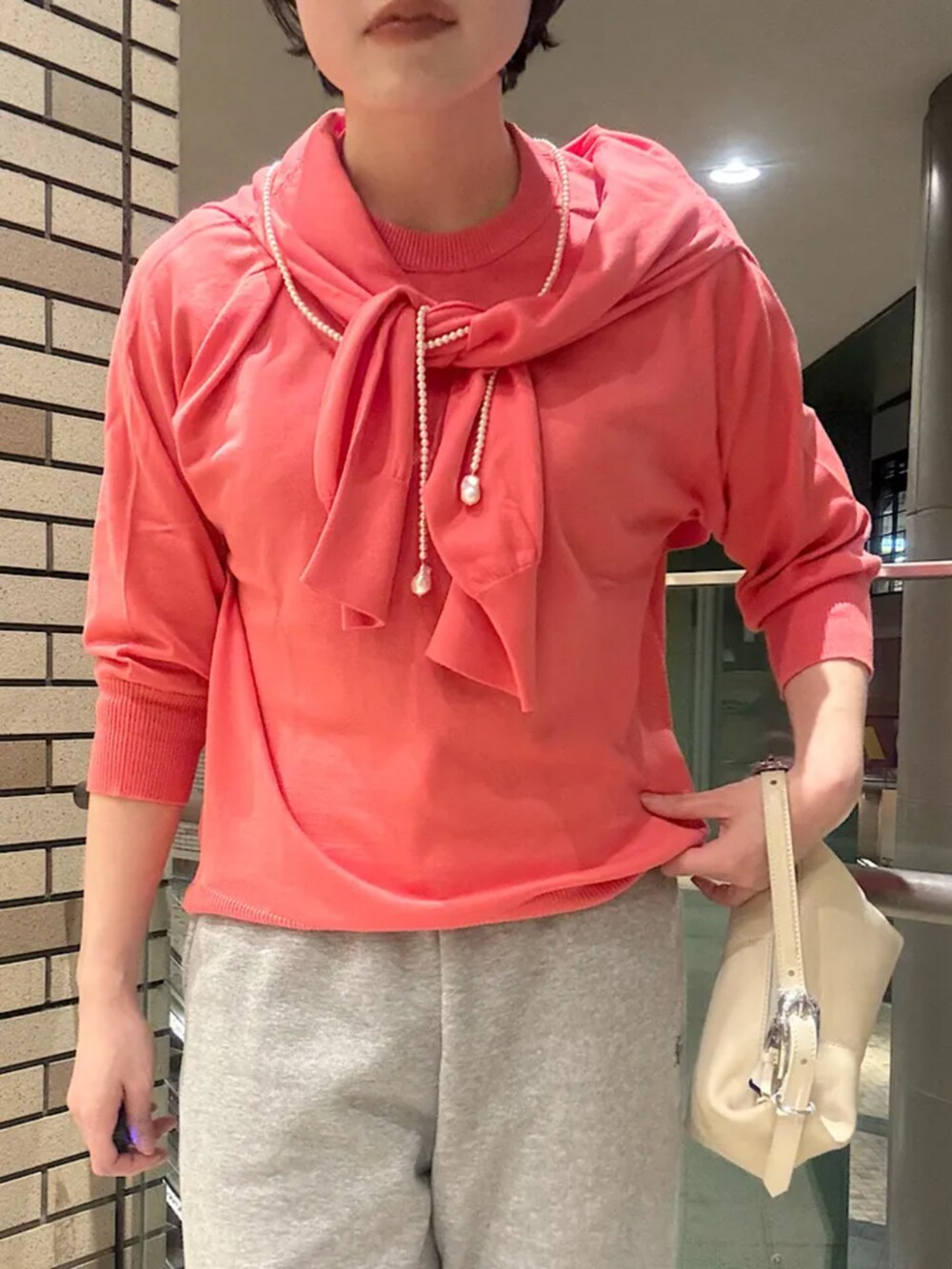 シルバー系のパンプス、ピンク系のカーディガン/ボレロ、ピンク系のニット/セーターを着用したレディースの冬コーディネートの2枚目の写真