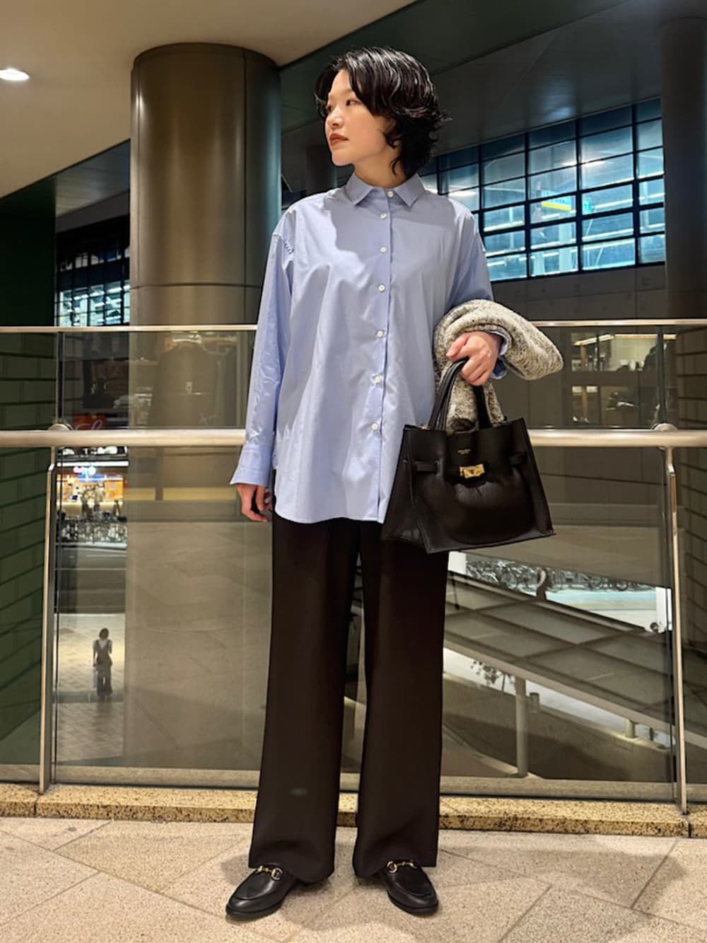 ブルー系のシャツ/ブラウス、ブラック系のトートバッグ、ベージュ系のカーディガン/ボレロを着用したレディースの秋コーディネートの2枚目の写真