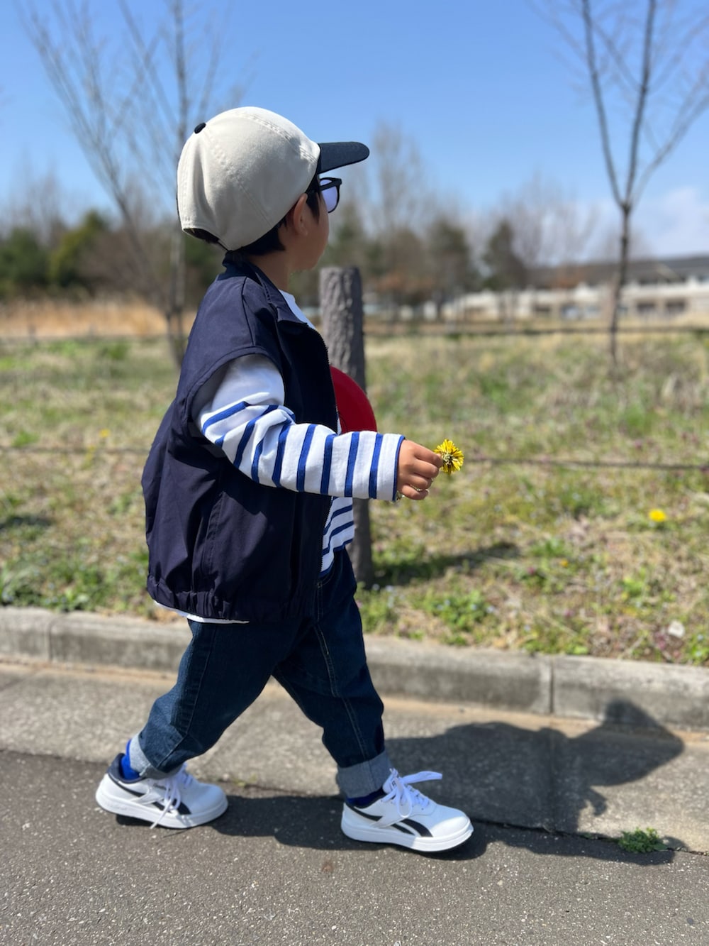 ブルー系のTシャツ/カットソー、ブルー系のベスト、ブルー系のデニムパンツを着用したレディースの春コーディネートの2枚目の写真