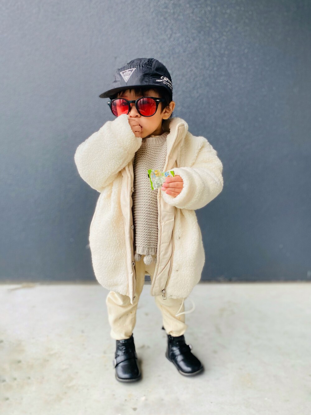 ホワイト系のブルゾン、グレー系のニット/セーター、ホワイト系のデニムパンツを着用したキッズの冬コーディネートの3枚目の写真