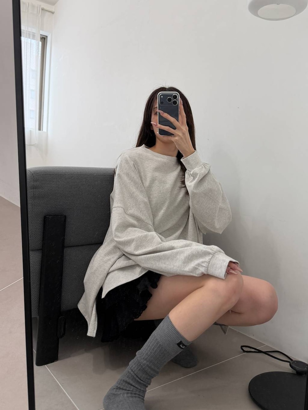 ブラック系のスカート、ベージュ系のTシャツ/カットソー、グレー系のソックス/靴下を着用したレディースの春コーディネートの2枚目の写真