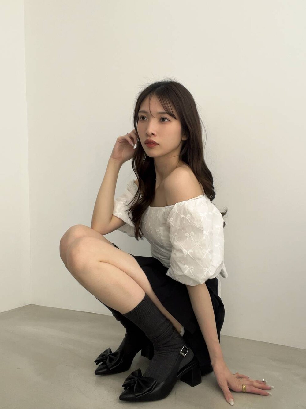 ブラック系のサンダル、ブラック系のスカート、ホワイト系のシャツ/ブラウスを着用したレディースの夏コーディネートの2枚目の写真