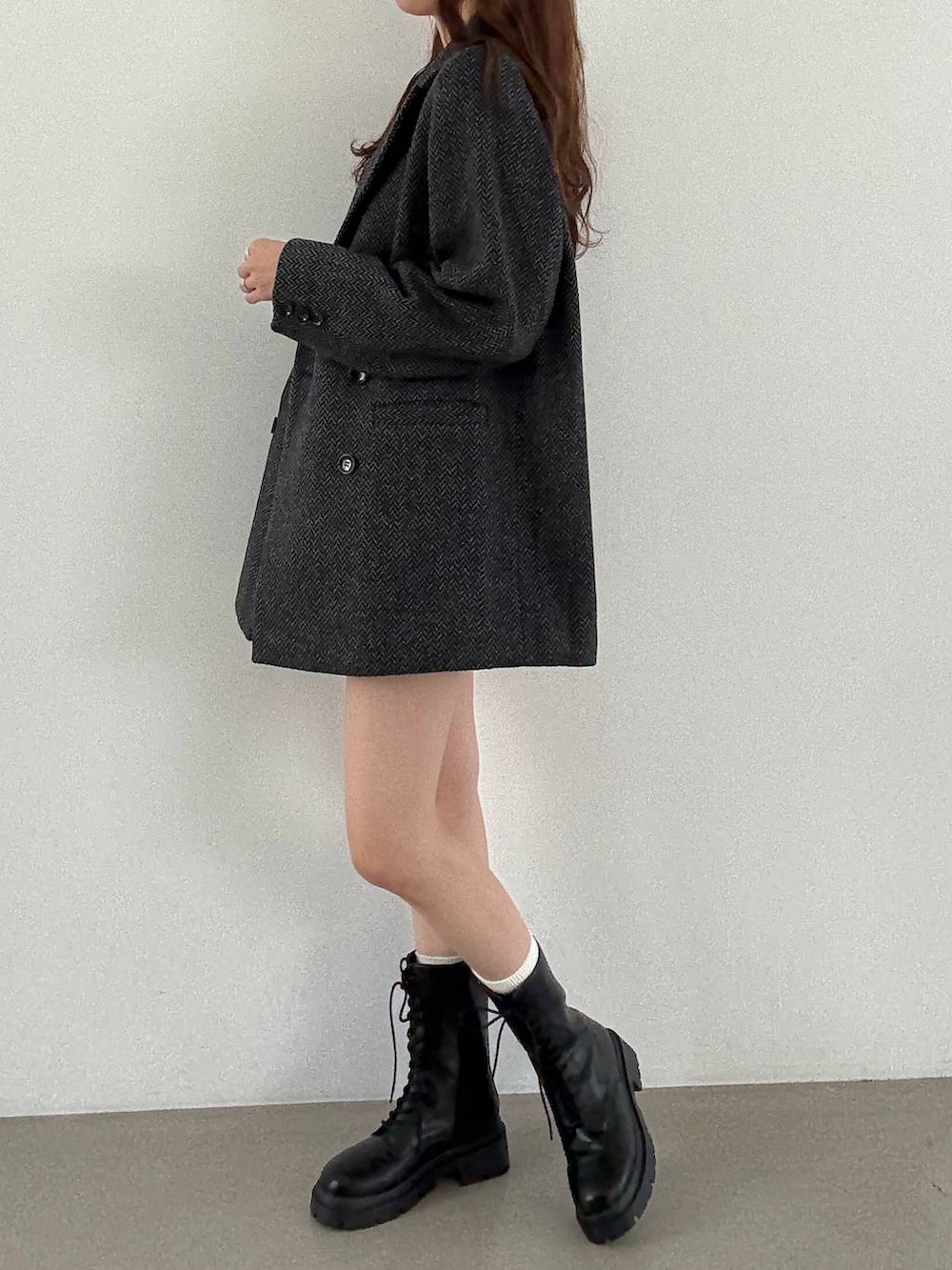 グレー系のテーラードジャケット、ブラック系のキャミソール、ブラック系のブーツを着用したレディースの秋コーディネートの4枚目の写真