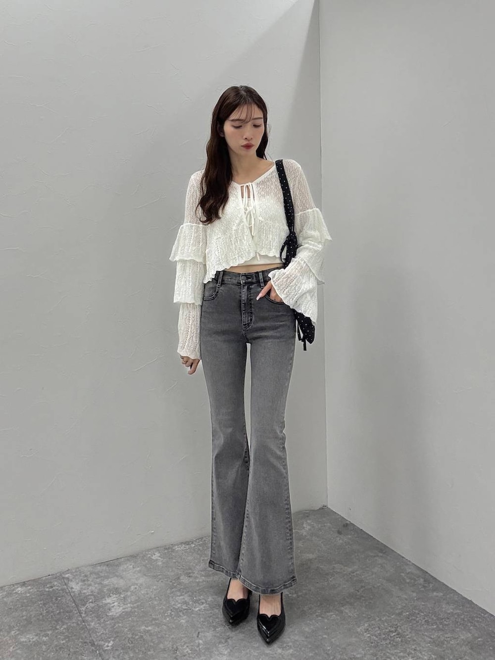 ホワイト系のキャミソール、ブラック系のサンダル、グレー系のデニムパンツを着用したレディースの夏コーディネートの4枚目の写真