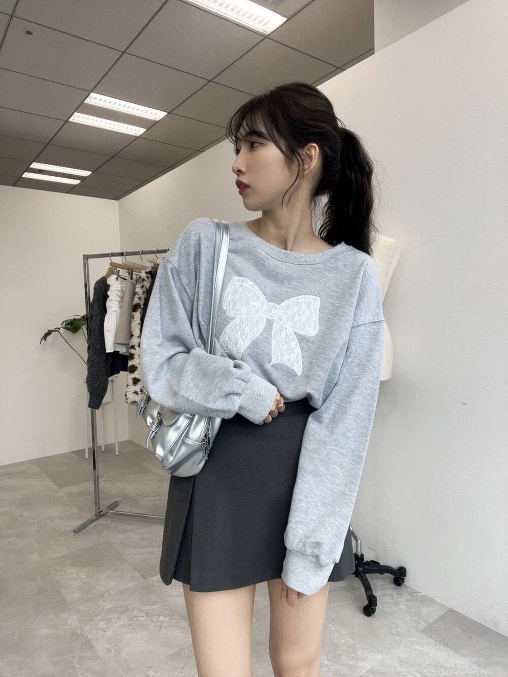 グレー系のスウェット、シルバー系のショルダーバッグ、グレー系のスカートを着用したレディースの秋コーディネートの4枚目の写真
