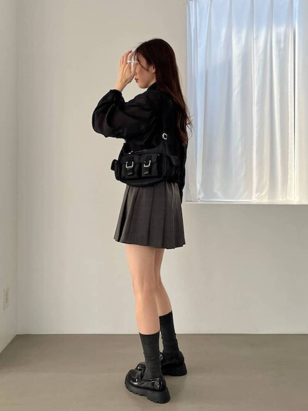 ブラック系のブルゾン、ブラック系のローファー、グレー系のスカートを着用したレディースの夏コーディネートの6枚目の写真