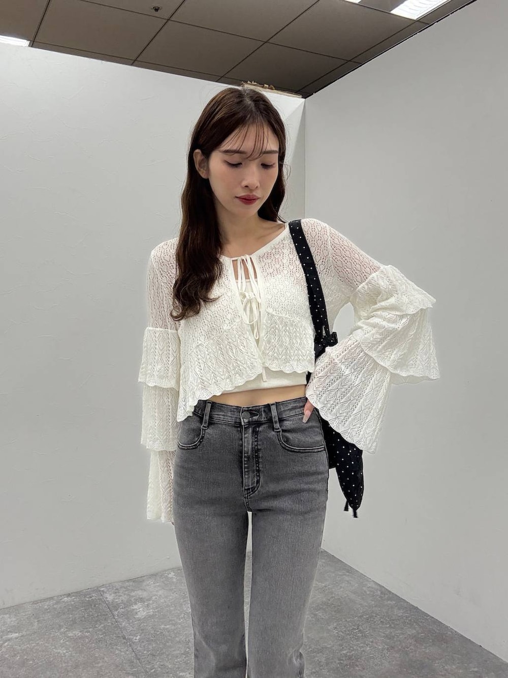 ホワイト系のキャミソール、ブラック系のサンダル、グレー系のデニムパンツを着用したレディースの夏コーディネートの3枚目の写真