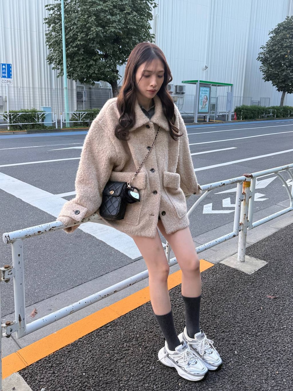 ベージュ系のその他アウター、ブラック系のショルダーバッグを着用したレディースの秋コーディネートの2枚目の写真