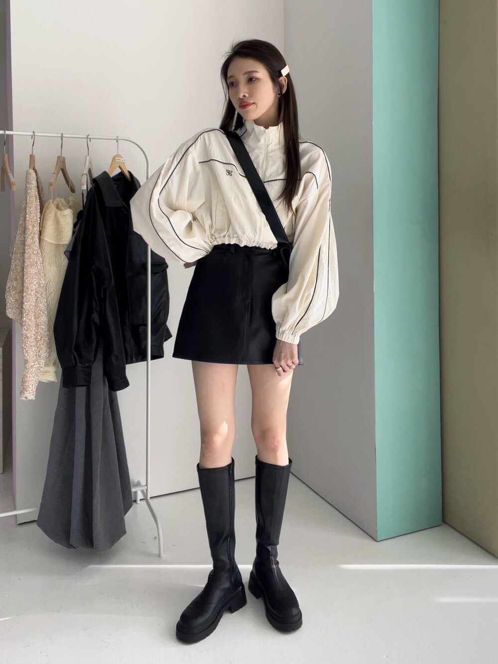 ブラック系のボディバッグ/ウエストポーチ、ホワイト系のナイロンジャケット、ブラック系のブーツを着用したレディースの冬コーディネートの2枚目の写真