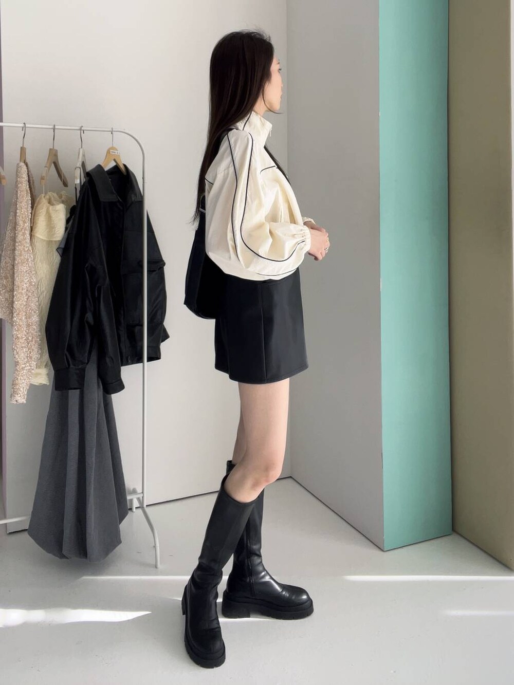 ブラック系のボディバッグ/ウエストポーチ、ホワイト系のナイロンジャケット、ブラック系のブーツを着用したレディースの冬コーディネートの3枚目の写真