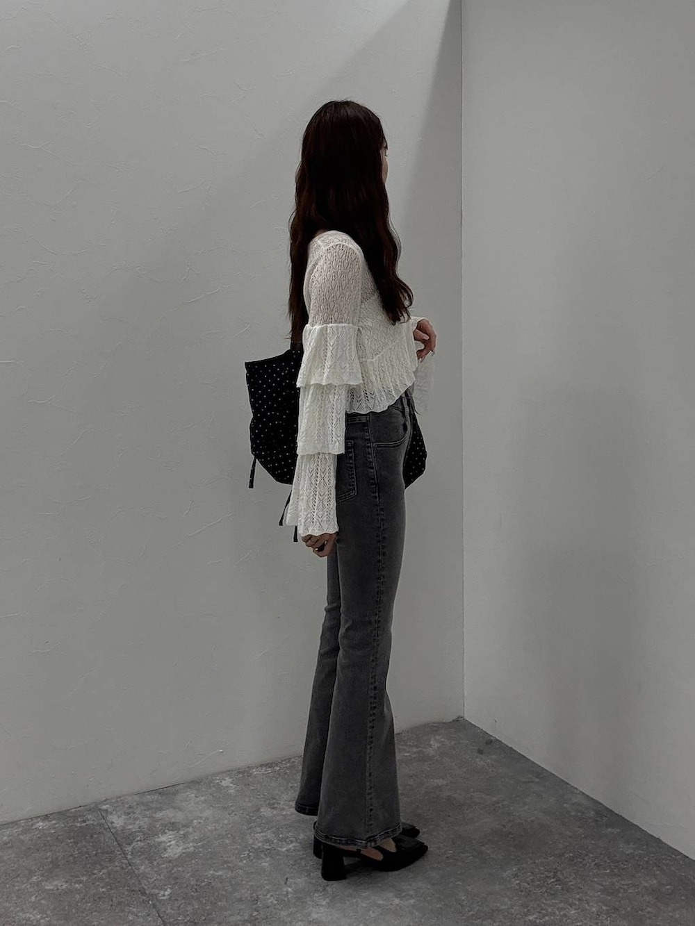 ホワイト系のキャミソール、ブラック系のサンダル、グレー系のデニムパンツを着用したレディースの夏コーディネートの2枚目の写真